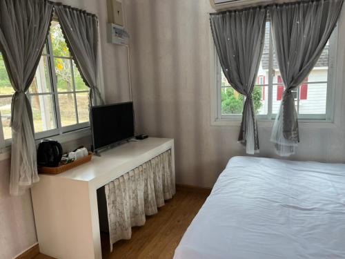 um quarto com uma cama e uma televisão numa cómoda em The Open Hills em Chongsadao