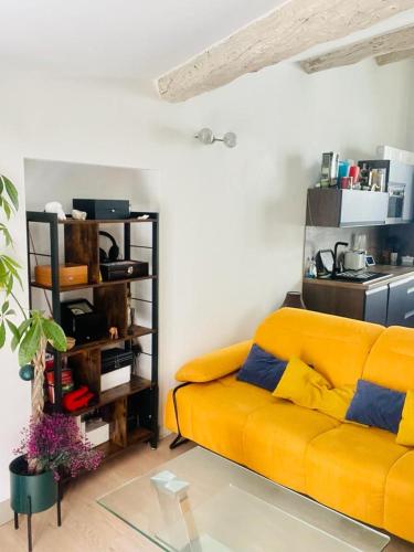 un salon avec un canapé jaune dans une pièce dans l'établissement La Terrasse des Arènes, à Nîmes