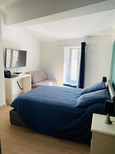 une chambre avec un lit bleu et une télévision dans l'établissement La Terrasse des Arènes, à Nîmes