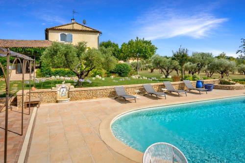 une piscine avec des chaises et une maison en arrière-plan dans l'établissement Appartement I Bastide La Gravière I Electio, à Lourmarin