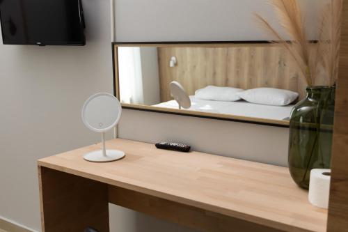 a bathroom with a mirror and a table with a mirror at Hotel United PR in Pristina
