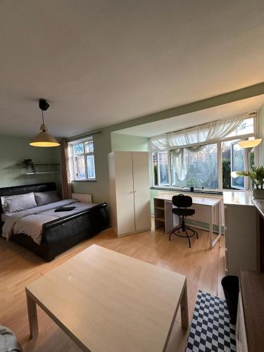een slaapkamer met een bed en een bureau in een kamer bij Whitechapel Rooms R3 in Londen