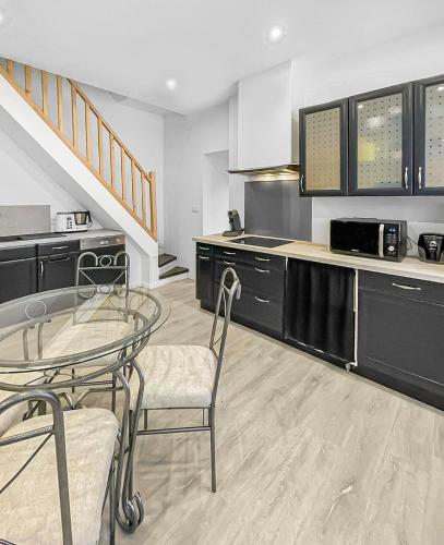 une cuisine avec une table, deux chaises et un comptoir dans l'établissement Douceur de Vivre à Saint-Amand-les-Eaux, à Saint-Amand-les-Eaux