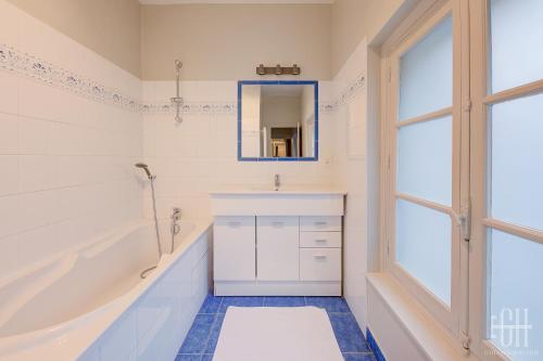 ein Badezimmer mit einer Badewanne, einem Waschbecken und einem Spiegel in der Unterkunft Le Jacobin - Saint Gatien- Bibliothèque in Tours