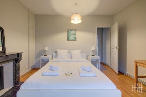 1 dormitorio con 1 cama blanca grande y toallas. en Le Jacobin - Saint Gatien- Bibliothèque, en Tours
