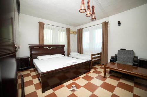 a bedroom with a bed and a desk and a couch at Hotel United PR in Prishtinë