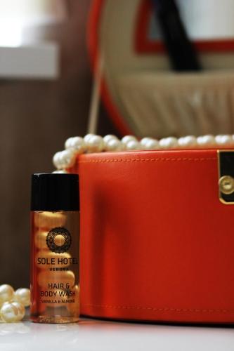 a bottle of hair products next to a red wallet at Sole Hotel Verona in Verona
