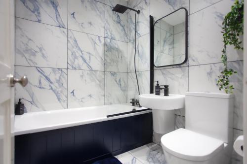 a bathroom with a toilet and a sink and a mirror at Templar large garden flat in London