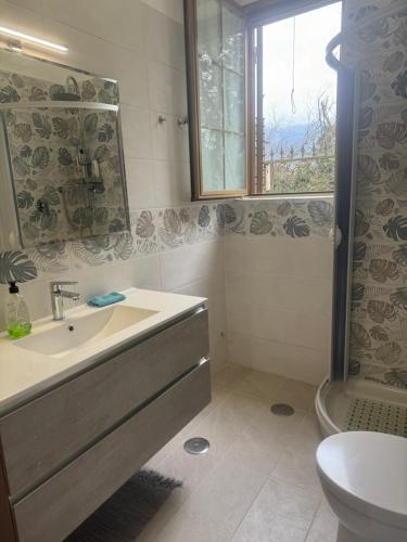 bagno con lavandino, servizi igienici e finestra di B&B Antica Forneria a Capaccio-Paestum