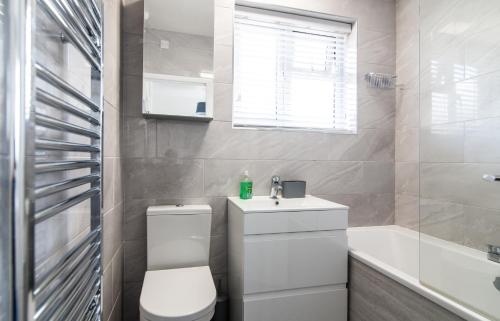 y baño con aseo, lavabo y bañera. en Immaculate home close to City Centre with large drive en Derby