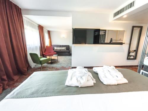 a hotel room with two towels on a bed at Mercure Belfort Centre in Belfort