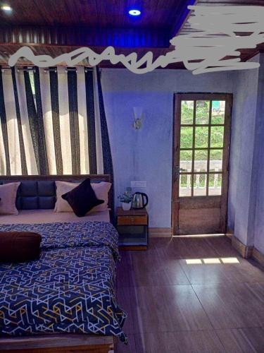 een slaapkamer met een bed, een raam en een deur bij PUBELA VILLA HOMESTAY in Darjeeling