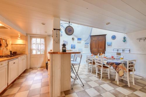 une cuisine avec une table et des chaises dans une pièce dans l'établissement Maison pour 6 - la Flotte - Hoomy, à La Flotte