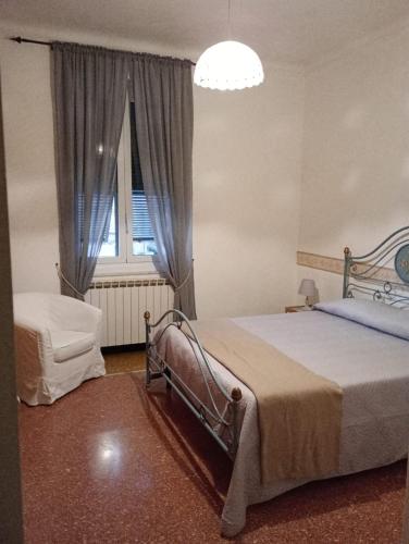 a bedroom with two beds and a window and a chandelier at Appartamento Billa in Deiva Marina
