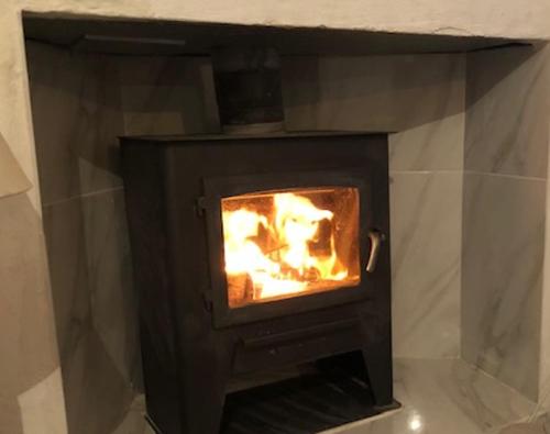 a black fireplace with a fire in it at The Crystal Cave in Zújar
