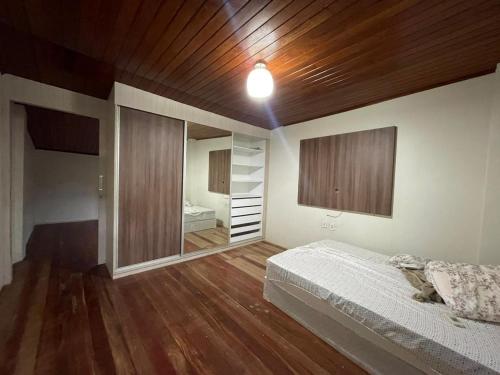 1 dormitorio con cama y espejo grande en Apt Amarração, en Luís Correia