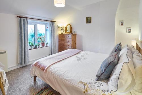 1 dormitorio con 1 cama con tocador y ventana en Host & Stay - Claire's Cottage, en Kent