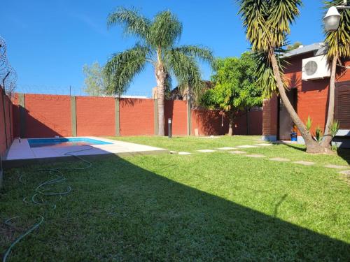 un cortile con prato verde, palme e recinto di Casa Quinta con Pileta a Presidencia Roque Sáenz Peña