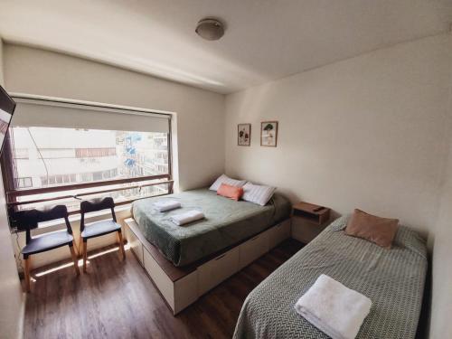 1 dormitorio con 2 camas y ventana en Green Studio en Buenos Aires
