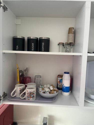 a shelf with food and other items in a kitchen at Self contained room, en-suite with separate lockable front door, located in an exclusive area in Wednesbury