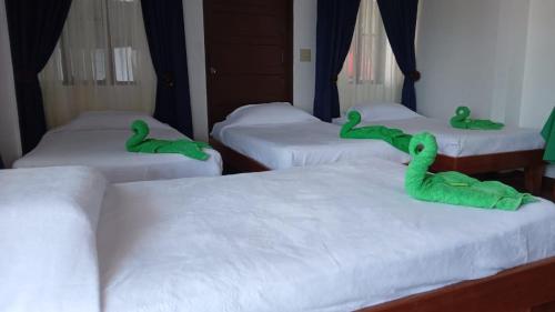 a room with four beds with green stuffed animals on them at Hotel Sierpe River- Oleaje Sereno in Sierpe