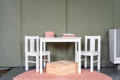 a white table with two chairs and a table with books at Pieter Stuyvesantkerk Peperga-Friesland in Peperga