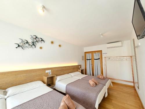 a hotel room with two beds and a television at PENSION ROSELLA in O Pedrouzo