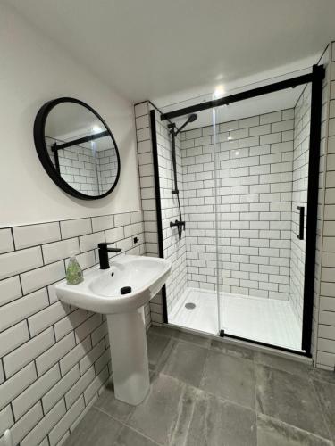 Un baño blanco con lavabo y ducha. en Scandic House, 1 Bed Apartments, Sleeps 2, Ulverston, en Ulverston