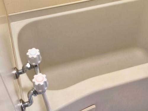 a white bath tub with a silver handle at Rest collection Fushimi-Inari Kyoto in Kyoto