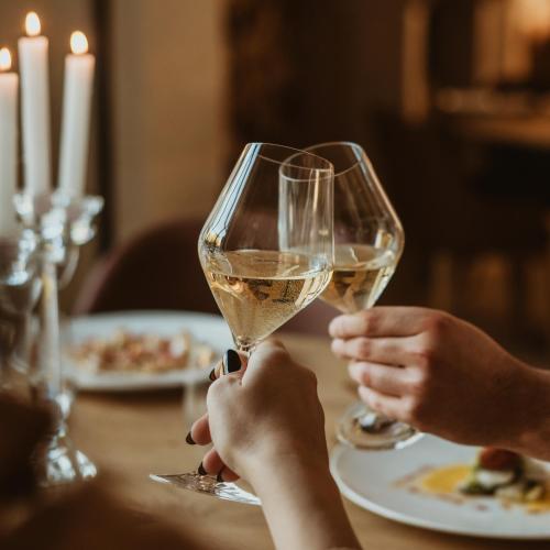 two people sitting at a table with glasses of wine at GAPO Rooms in Orta Nova