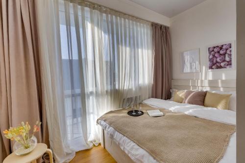 a bedroom with a bed and a large window at City Plus 285/8 in Almaty