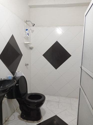 uma casa de banho com um WC preto e um lavatório. em Habitación en Cartagena para 2 personas em Cartagena das Índias