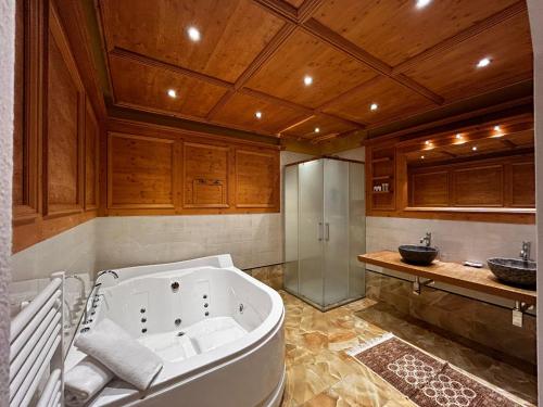 a large bathroom with a tub and a shower at Hotel El Mondin in Fiera di Primiero