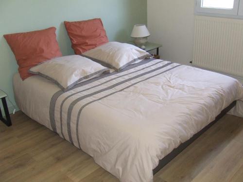 une chambre avec un grand lit blanc avec des oreillers rouges dans l'établissement Maison de vacances avec piscine, à Chânes