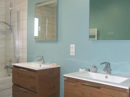 une salle de bain avec deux lavabos et un miroir dans l'établissement Maison de vacances avec piscine, à Chânes