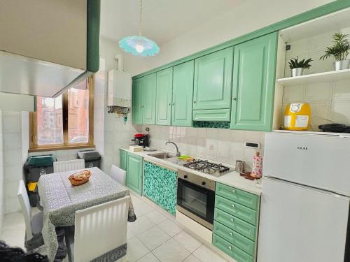 a kitchen with green cabinets and a table in it at Begonie House in Rome