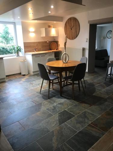 une cuisine et une salle à manger avec une table et des chaises dans l'établissement Duplex cosy LES SAULES, à Frémifontaine