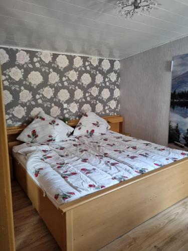 1 dormitorio con 1 cama con mantas y almohadas blancas en Ferienhaus Hochwald, 