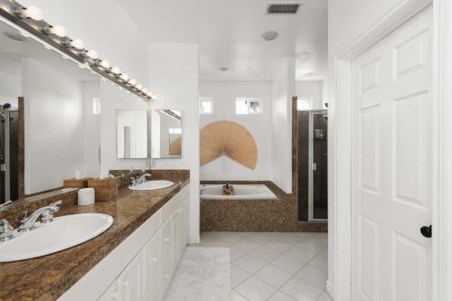 a white bathroom with two sinks and a tub at Modern beach home with rooftop - Ocean View! in Oceanside