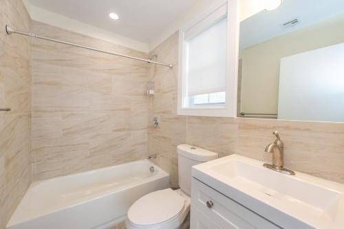 a bathroom with a white toilet and a sink at Chic Condo-NYC@Fingertips in North Bergen