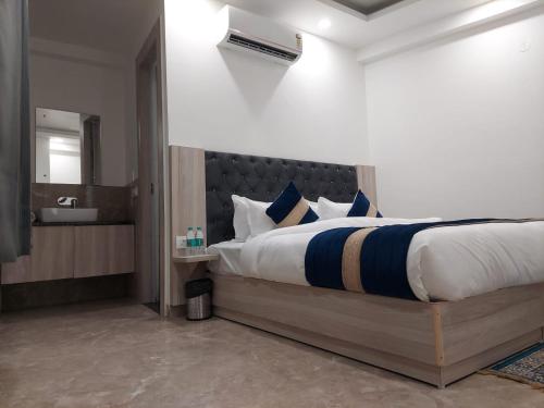 a bedroom with a large bed and a bathroom at Hotel Black Eye in New Delhi