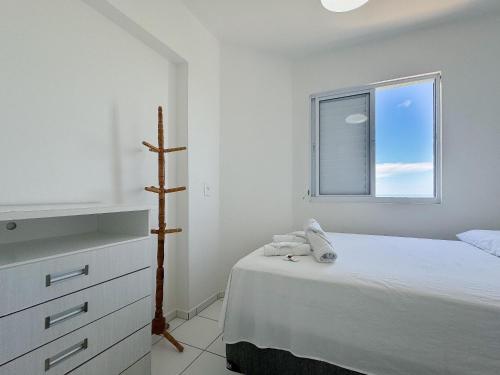 biała sypialnia z łóżkiem i oknem w obiekcie Resid. Clube Mar Grosso - Laguna w mieście Laguna