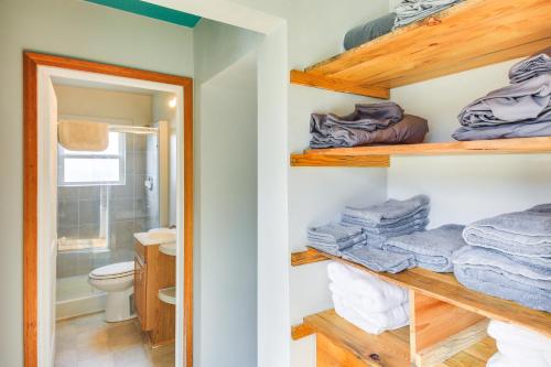 a bathroom with a toilet and towels on shelves at Clark Fork Vacation Home with Wood Stove Near Lake! in Clark Fork
