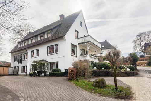 una casa blanca con techo negro en Ferienwohnung Greitemann en Eslohe