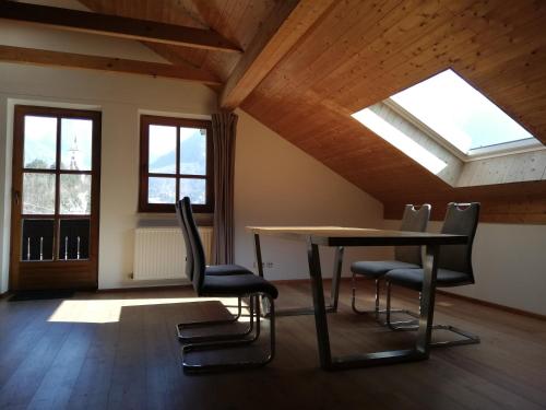 a table and chairs in a room with skylights at Seepanoramablick in Gmunden