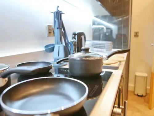 a kitchen with pots and pans on a stove at Pass the Keys Large Central Flat Walk To City Centre In 5 Mins in Manchester