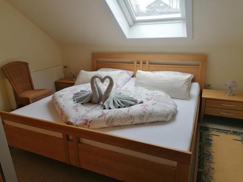 Una cama con dos toallas en forma de corazón. en Haus Rehblick 2, Wg 4 en Sankt Andreasberg