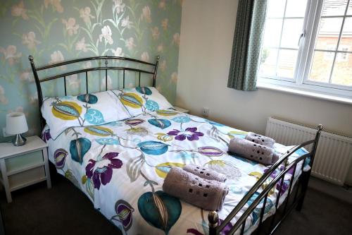 a bedroom with a bed with a floral bedspread at In Our Liverpool Home Sleeps 5 in 2 Double & 1 Single Bedrooms in Liverpool