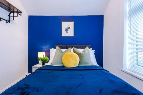 niebieska sypialnia z łóżkiem z żółtą poduszką w obiekcie Fantastic Five Bedroom House By PureStay Short Lets & Serviced Accommodation South Yorkshire With Parking w mieście Bentley