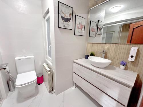 a white bathroom with a sink and a toilet at Nuevo: Cerca CENTRO , WIFI y Calefacción in Oviedo